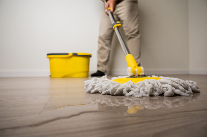 homem limpando o chão com um mop