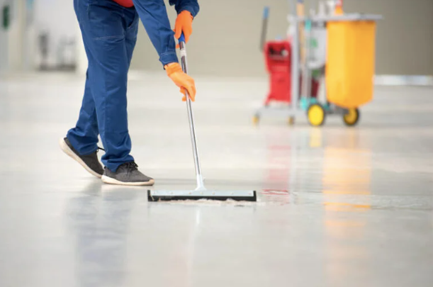 Homem passando rodo de limpeza em piso