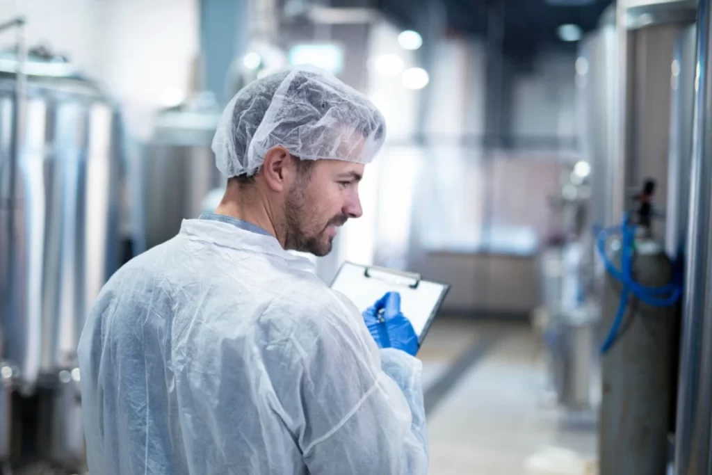 Técnico inspecionando indústria, representando o manual de higienização na indústria alimentar.