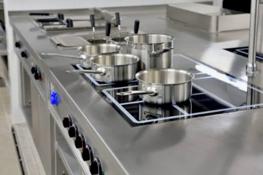 Bancada de cozinha industrial com cooktop deindução e panelas