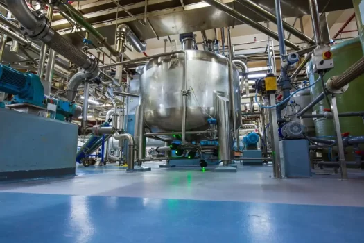 Planta industrial com equipamentos de produção, representando a limpeza industrial.